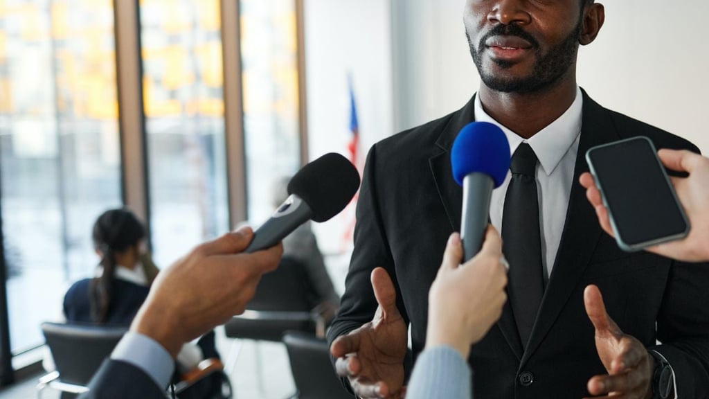 A journalist writing some notes and holding two microphones