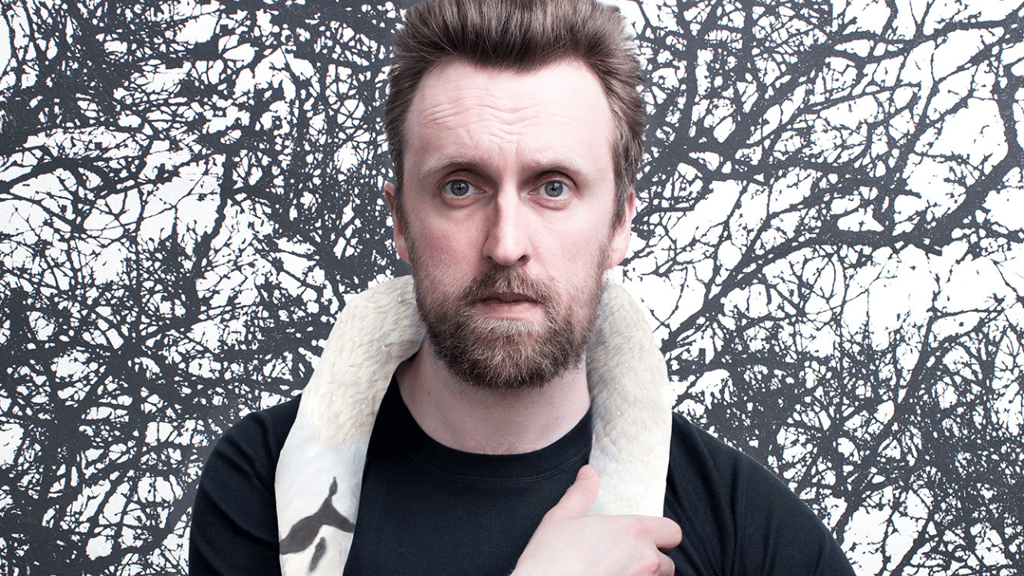 Image of comedian Matt Winning who is wearing a swan around his neck
