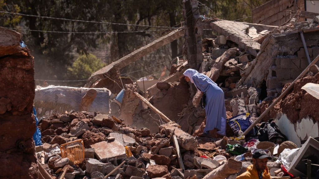 A woman looks into the rubble of a collapsed building on September 10, 2023 in Moulay Brahim, Morocco.
