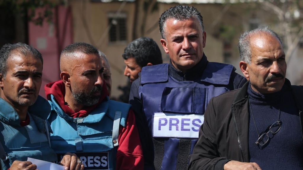 L'image montre un groupe de journalistes couvrant Gaza