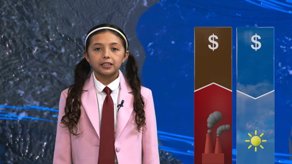 Il s'agit d'une photo d'une jeune fille, vêtue d'une veste de costume rose, d'une chemise blanche et d'une cravate marron, debout devant une carte météo, présentant la météo pour une émission télévisée.