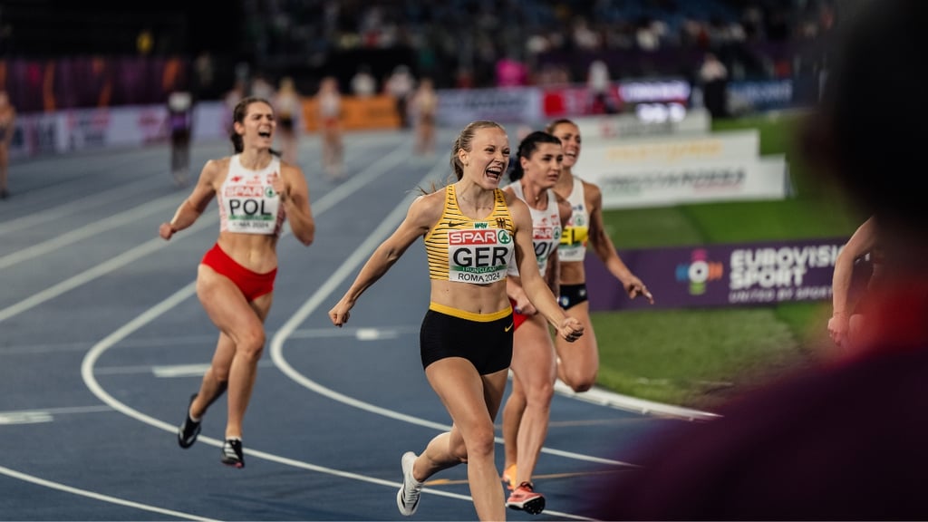 This is a photograph of a runner celebrating reaching the end of her race