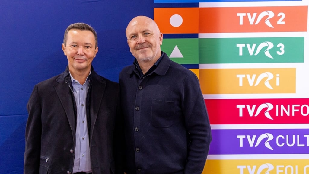 Dan Cristian Turturică, président-directeur général de la Société roumaine de télévision, et Glen Killane, directeur exécutif d'EBU Sport, se tiennent côte à côte, souriants, devant un arrière-plan orné des logos colorés des chaînes TVR, dont TVR2, TVR3, TVRi, TVR Info et TVR Cultural. Tous deux portent des vestes sombres sur fond bleu.