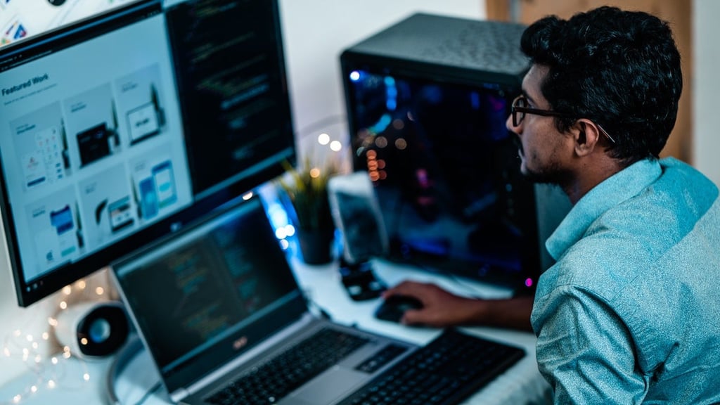 Man in blue shirt and glasses looking at computer